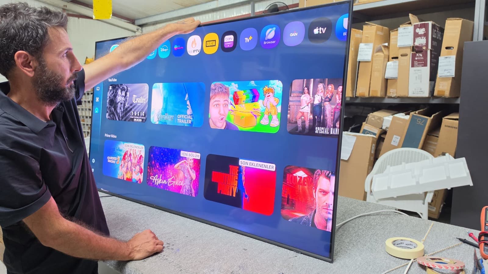 Zorlu Digital Plaza teknisyeni atölyede onarımı tamamlanan büyük ekran Smart TV'yi test ediyor